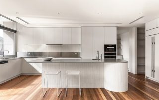 Architectural Joinery | Seamless Integration Modern kitchen with sleek cabinetry, integrated appliances, and a sculptural island, highlighting the seamless integration and precision of architectural joinery.
