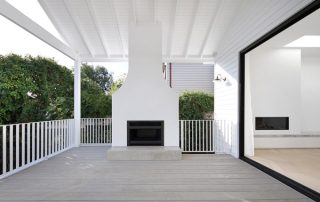 Indoor-Outdoor Flow with Fireplace Feature Modern outdoor living space with the fireplace as focal point and expansive covered patio, highlighting indoor-outdoor flow, crisp white colour palette, and view of interior fireplace.