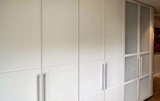 Bespoke Joinery Design | Woven Metal Mesh Inserts A multi-functional bespoke cabinetry unit featuring an integrated bar and fridge behind panelled doors with woven metal mesh inserts. The end of the cabinet features custom double curved doors.