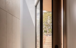 Bespoke Entryway Design with Functional Storage A custom-designed entryway featuring three ceiling-height storage cabinets with an unfinished surface. The angle highlights the bespoke bench seat with integrated joinery alongside the cabinetry.