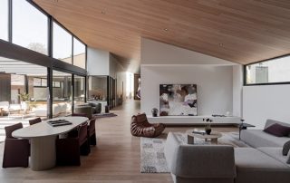 Contemporary Living Room | Custom Concealed Storage Joinery A modern furnished living room featuring custom joinery on the facing wall with concealed storage and a sleek bottom fingerpull design. The Natural White Matt finish integrates seamlessly into the minimalist aesthetic.