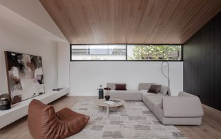 Minimalist Living Room with Sleek Custom Storage Solutions A modern living room showcasing a bespoke concealed storage unit with a sleek white finish and designed with fingerpull from bottom, seamlessly blending functionality and minimalist aesthetics.