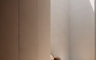 Modern Entryway | Bespoke Cabinetry and Bench Seat A bespoke entryway featuring three ceiling-height hallway cabinets designed for storage, with an unfinished surface. Adjacent to the cabinets is a bespoke bench seat with integrated joinery, offering both functionality and style.