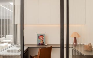 Bespoke Study Room Joinery | Integrated Lighting A modern home study room featuring wall-integrated joinery with an Empire Oak Woodmatt finish on the desk and drawers. Overhead cabinets in a Natural White Matt finish include integrated lighting, creating a functional and elegant workspace.