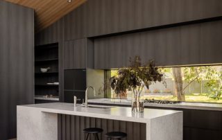 Bespoke Design Angular Kitchen Island | Custom Paneling A contemporary kitchen featuring bespoke architectural joinery in an Empire Oak Woodmatt finish, a central angular island with custom paneling, and a custom walk-in pantry.