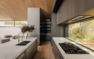 Architectural Joinery | Modern Kitchen Masterpiece A contemporary kitchen featuring bespoke joinery in an Empire Oak Woodmatt finish with integrated appliances, a custom design walk-in pantry, and bespoke island showcasing integrated appliances.