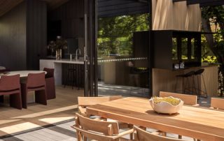 Integrated Indoor-Outdoor Living | Architectural Design An outdoor view of a luxury home which showcases indoor-outdoor spatial flow. Multiple seating areas provide space for entertaining and a pass-through kitchen window connects the indoor and outdoor kitchens.