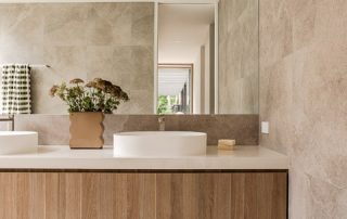 Bespoke Floating Vanity | Modern Ensuite Design Bespoke floating vanity with a Polytec 'Maison Oak Ravine' vertical grain finish, Sharknose Fingerpull soft-close drawers, and a Caesarstone 'Organic White' countertop with integrated sinks and bespoke tapware.