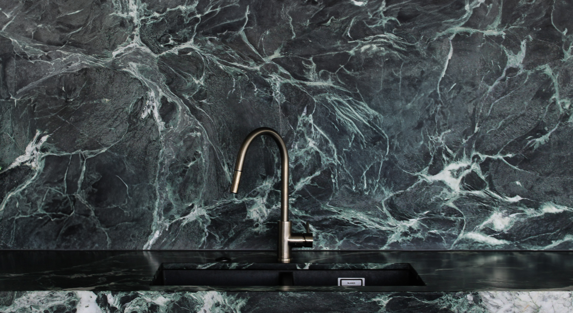 Luxury kitchen benchtop and splashback with integrated sink featuring Corsi + Nicolai Verde St Denis marble.