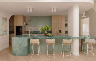 Precision Joinery Meets Sculptural Design A modern kitchen featuring precision custom joinery and sculptural stone island in a neutral palette.