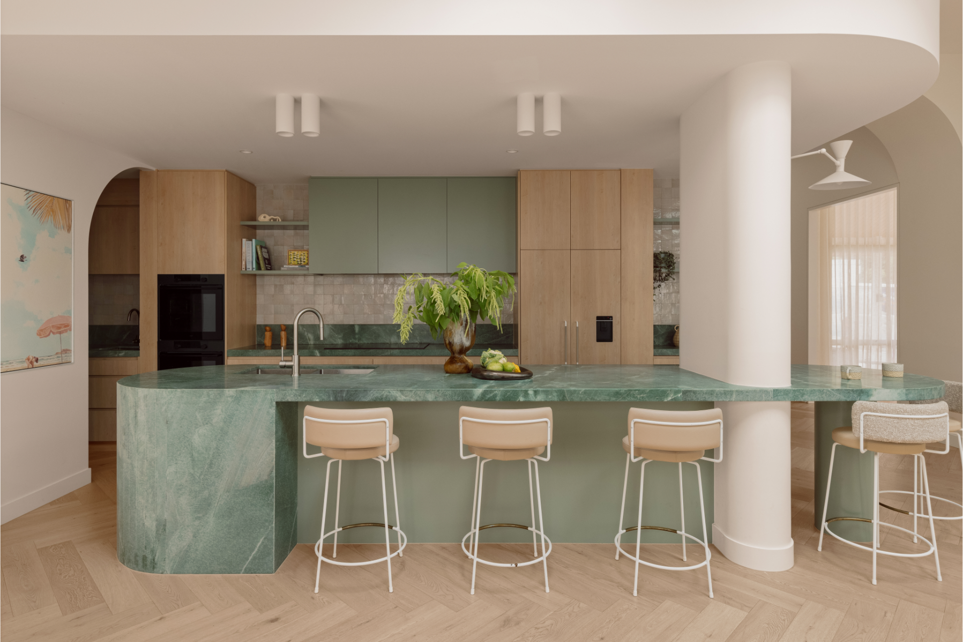 A modern kitchen featuring precision custom joinery and sculptural stone island in a neutral palette.
