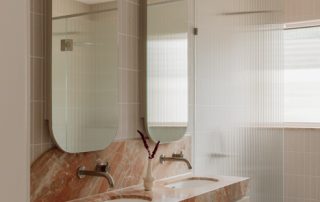 Hampton Residence – Bathroom Custom double vanity with a rich stone countertop, brushed metal tapware, and precision crafted joinery.
