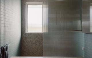 Hampton Residence – Bathroom Custom bathroom joinery set against textured stone in a modern space.